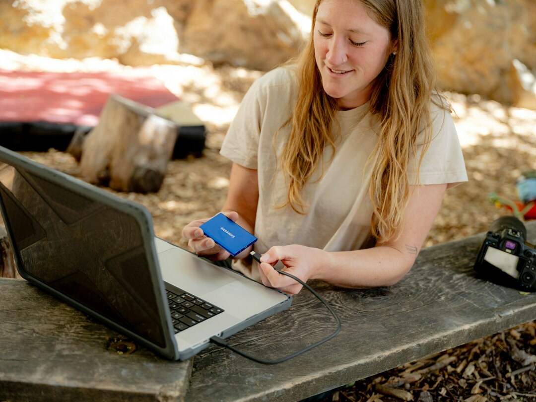 Student taking notes beside an open laptop with code