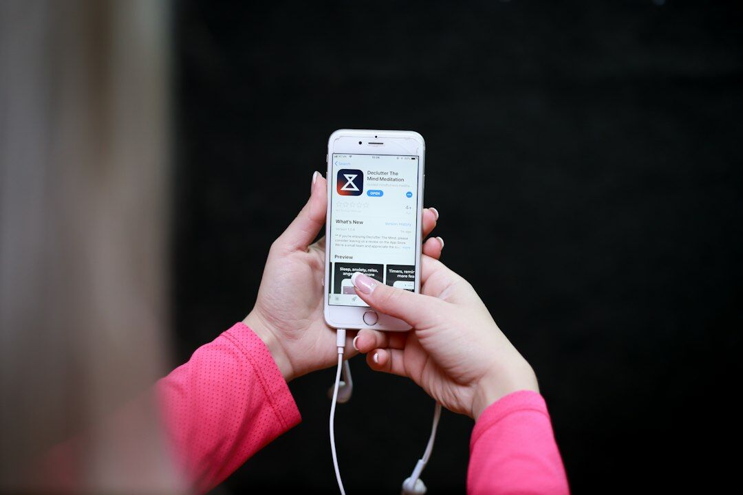 Hands holding a smartphone displaying an app interface