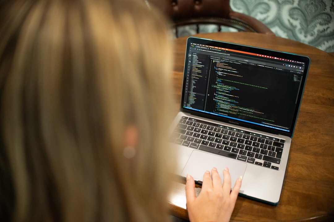 woman writing code on laptop